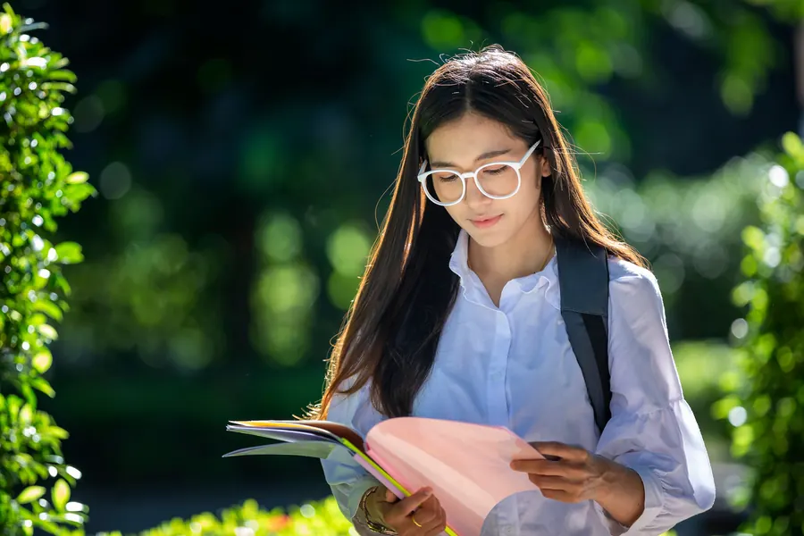 Estudiante leyendo apuntes al aire libre